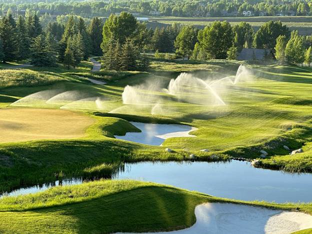 A water sprinklers spraying water on a golf course

AI-generated content may be incorrect.