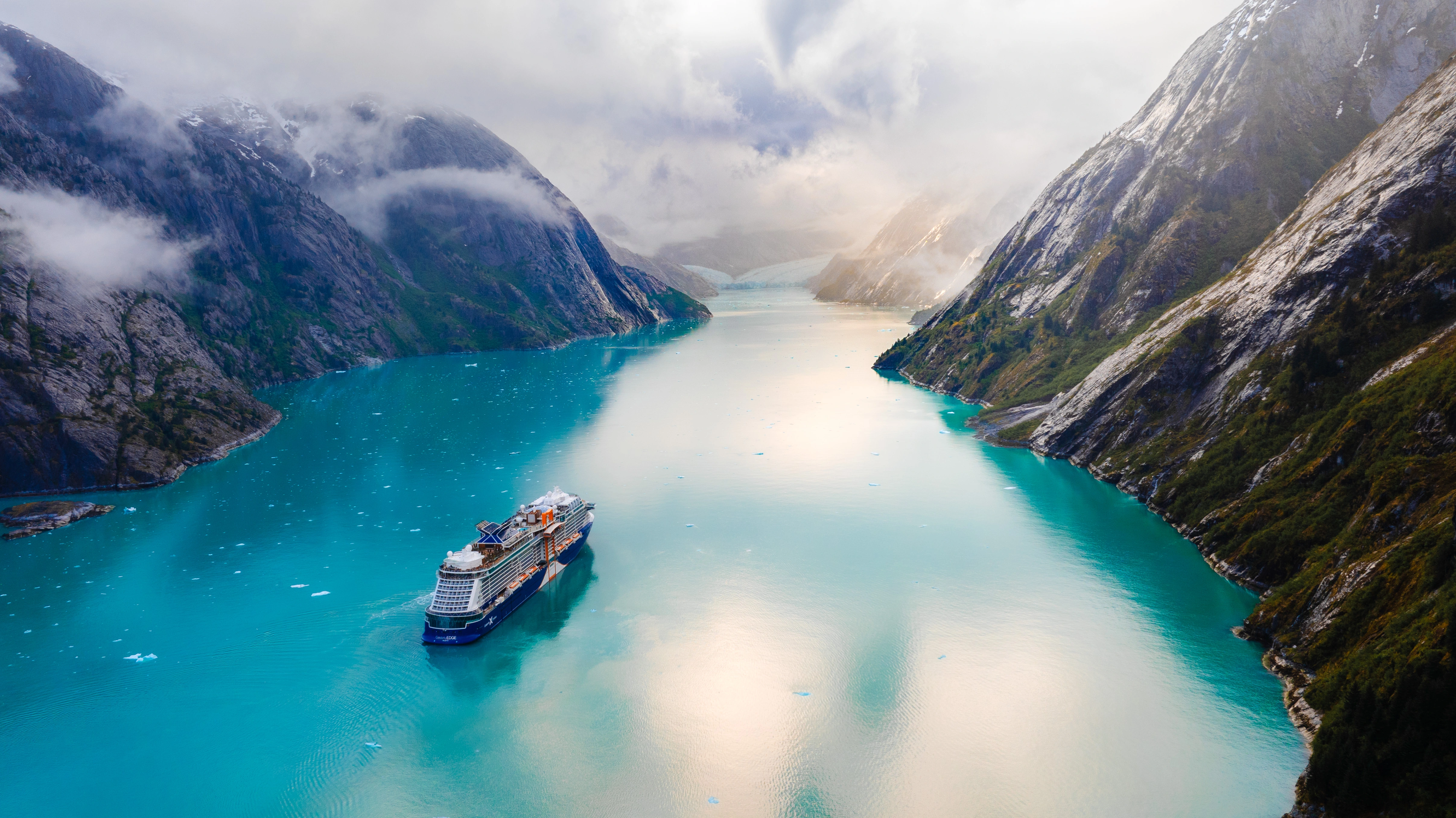 Celebrity Cruises ship sailing between the mountains in Alaska.