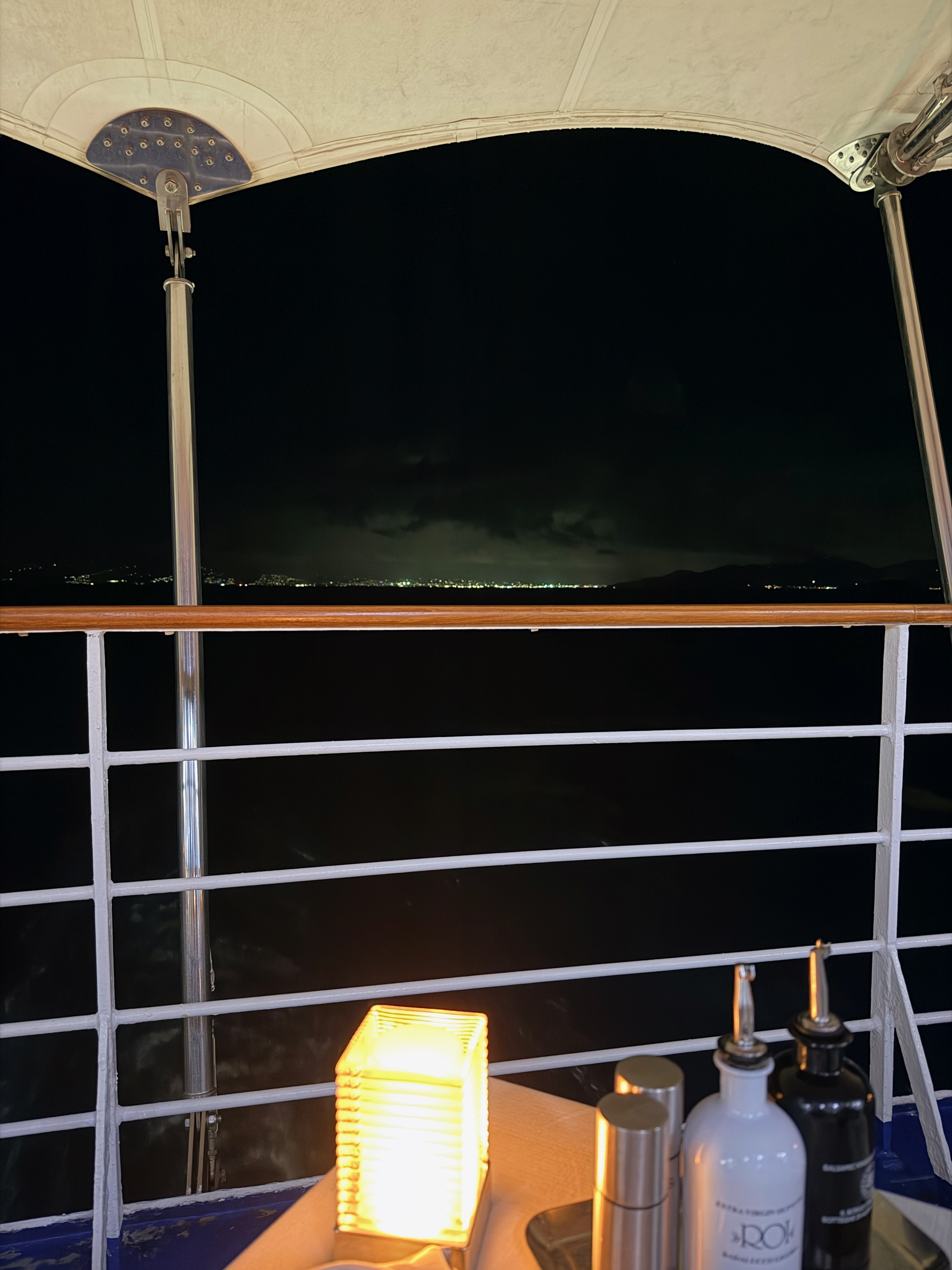night view sailing away from Martinique with dining table in the foreground